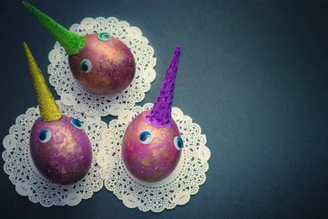 Easter cosmic colored unicorns eggs with eyes on black background. Copy space Stockfoto's