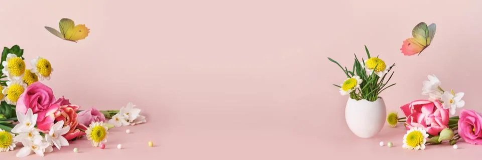 Easter creative composition. Spring flowers, Easter egg and butterflies on pink Stock Photos