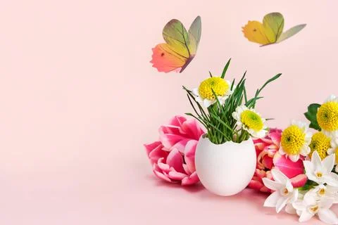 Easter creative composition. Spring flowers, Easter egg and butterflies on a Foto stock