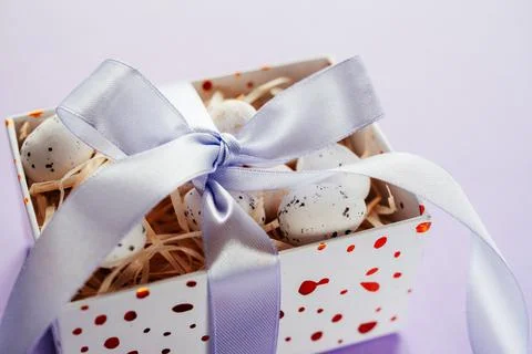 Easter creative layout with Easter eggs in a gift box with lavender blush Stock Photos