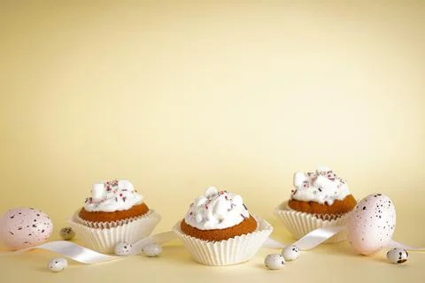 Easter cupcakes and easter eggs, funny easter treats on yellow background, pl Stock Photos