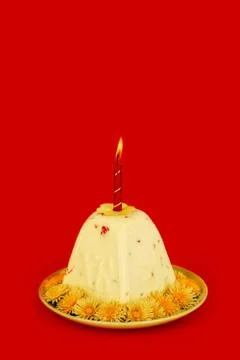 Easter curd cake with a burning candle on a red background close-up 스톡 사진