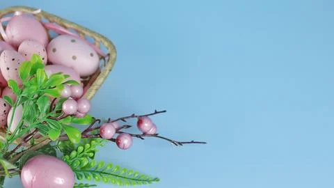 Easter decor. A branch with decorations on a blue monochromatic background Stock Photos