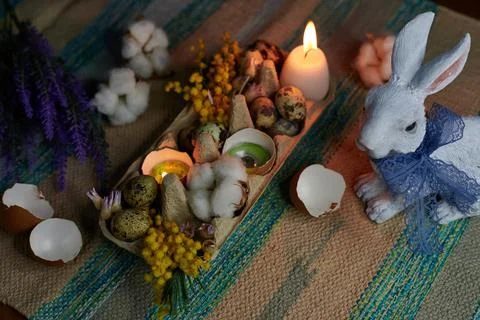 Easter decor in an egg box with candles, hare and dried flower Stock Photos