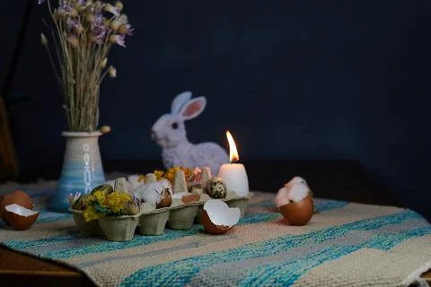 Easter decor in an egg box with dried flowers and candles with a hare Stock Photos