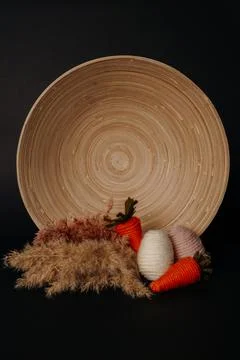 Easter decor. knitted decor eggs, carrots and pampas on bamboo plate Stock Photos