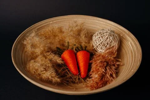 Easter decor. knitted decor eggs, carrots and pampas on bamboo plate Stock Photos