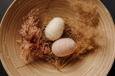 Easter decor. knitted decor eggs and pampas on bamboo plate Stock Photos