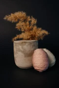 Easter decor. two knitted eggs concrete candle and pampas Stock Photos