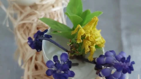 Easter decoration with eggshells yellow sisal and spring flowers close up Vídeos de archivo 333641701