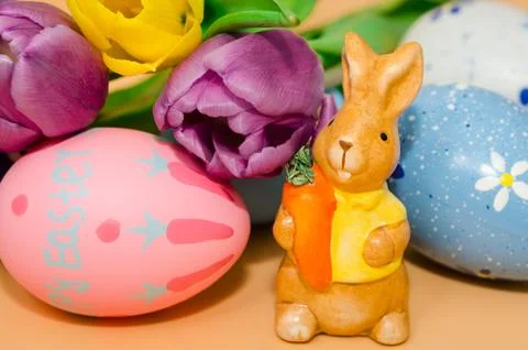 Easter decoration with rabbit, eggs and tulips, orange background Stock Photos