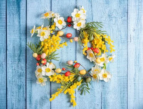 Easter decoration. A wreath of daffodils, mimosa and twigs with colorful quail Stock Photos