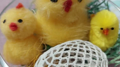 Easter decoration with yellow fluffy chicks and crochet egg in a glass bowl Stock Footage 333641798