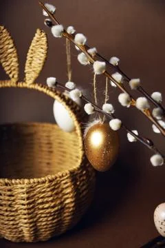 Easter decorations, a basket with cute rabbit ears. Painted eggs hang on pu.. Stock Photos
