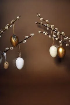 Easter decorations on a brown background. Painted eggs hang on pussy willow.. Foto stock