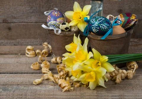 Easter decorative eggs in a pot and flowers of narcissus Stock Photos