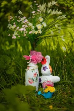 Easter decorative elements, vase with artificial flowers, bunny toy Stock Photos