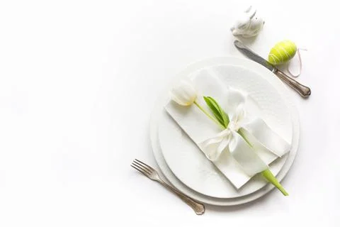 Easter dinner. Table setting with white tulip on white table. Top view. Stock Photos