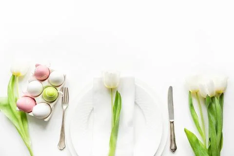Easter dinner. Table setting with white tulip on white table. Top view. Stock Photos