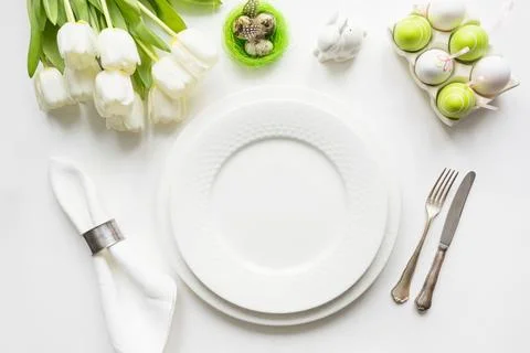 Easter dinner. Table setting with white tulip on table. Top view. Stock Photos