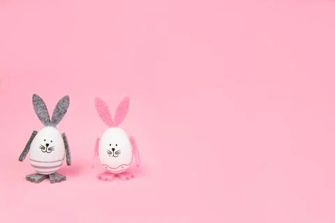 Easter. Easter bunnies, with their own hands on a pink background. mocap Stock Photos