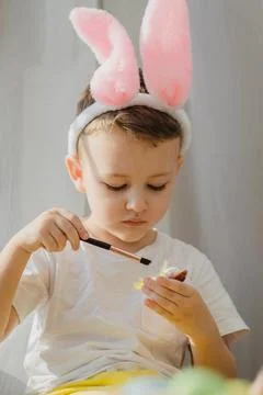 Easter. Easter concept. Boy in bunny ears paint easter eggs. Paint eggs for Foto stock