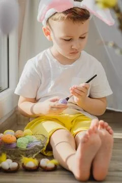 Easter. Easter concept. Boy in bunny ears paint easter eggs. Paint eggs for Foto stock