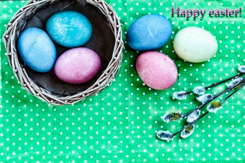 Easter. Easter eggs in a basket on a green background and colored ribbons. Ha Stock Photos