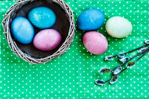 Easter. Easter eggs in a basket on a green background and colored ribbons. Ha Foto stock