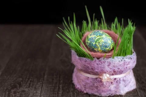 Easter egg and sprouts of wheat on the wooden surface. Low key, selective focus 스톡 사진