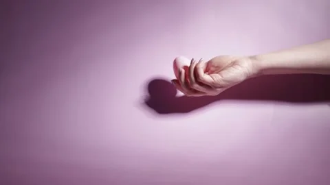Easter egg and woman's hand on a pink background, delicate touch, festive d.. Stock Footage 262145310