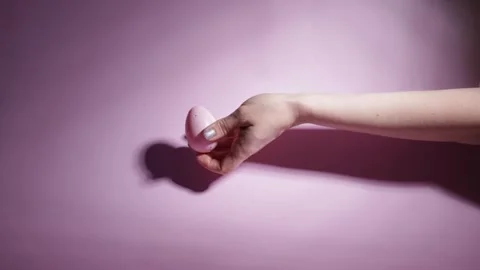 Easter egg and woman's hand on a pink background, fingers on a decorated eg.. Stock Footage 262145382