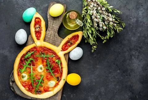 Easter egg basket with chocolate eggs and flowers on dark background Stock Photos