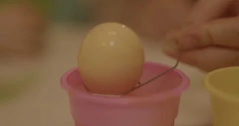 Easter egg being pulled from the orange dye Stock Footage 239221234