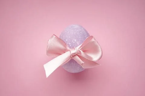 Easter egg with a bow on a pink background. Top view Stock Photos
