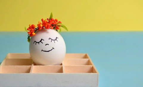 Easter egg in a box on a yellow-blue background. Easter. Stock Photos