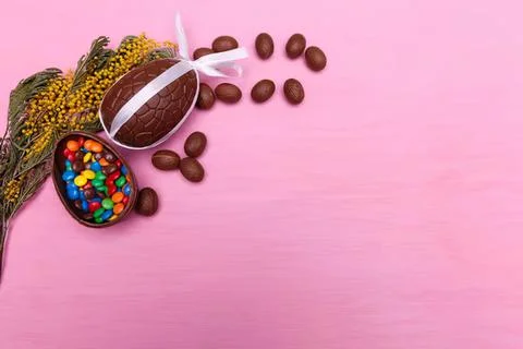 Easter egg with chocolates and candies on pink background Stock Photos