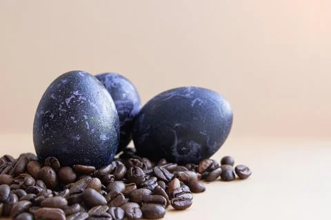 Easter egg in coffee beans. The egg is blue. On a light background Stock Photos