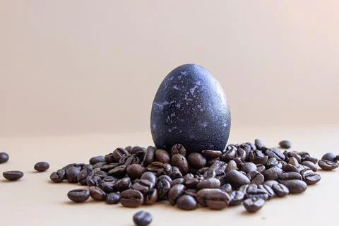 Easter egg in coffee beans. The egg is blue. On a light background Stock Photos