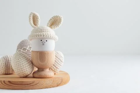Easter egg in crochet hat with bunny ears in wooden egg holder 写真素材