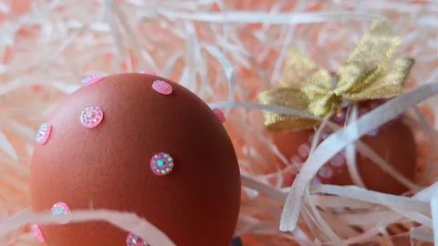 Easter egg, decorated with pink rhinestones among the straw Stock Footage 104589671
