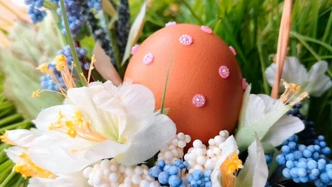 Easter egg decorated with rhinestones in Easter basket among spring flowers Stock Footage 104589681