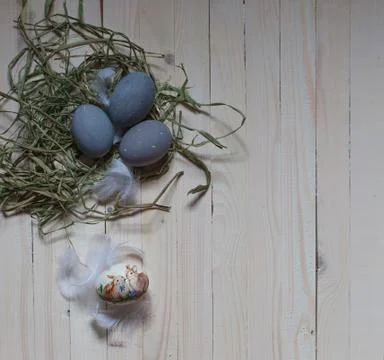 Easter egg with easter bunnies and three grey eggs in green shavings and whit Stock Photos
