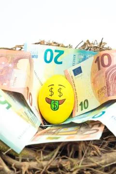 Easter egg with facial expression "I love money" placed on euro paper money. Stock Photos