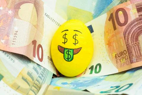 Easter egg with facial expression "I love money" placed on euro paper money. Stock Photos