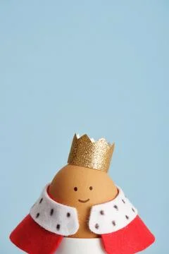 Easter egg featuring king with crown and red robe close up on blue backgrou.. Stock Photos
