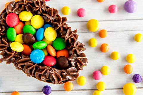 Easter egg filled with chocolate and confetti, easter concept on white back.. Stock Photos