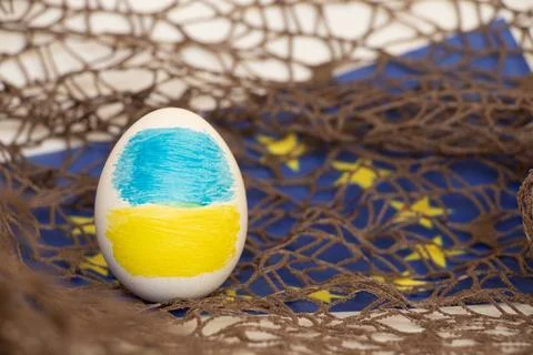 Easter egg with the flag of Ukraine against the background of the flag of t.. Stock Photos