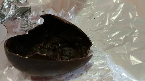 An Easter egg has been opened, the broken chocolate shell is on the table Stock Footage 106887551
