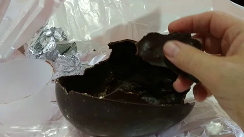 An Easter egg has been opened, the broken chocolate shell is on the table Stock Footage 106887889